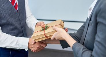Zwei Geschäftsleute, die sich ein Geschenk überreichen